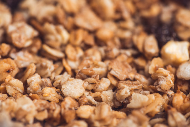 美味实用的什锦麦片，有坚果、葡萄干和薄片。选择性聚焦微距拍摄非常浅的景深。健康素食的生活方式图片下载