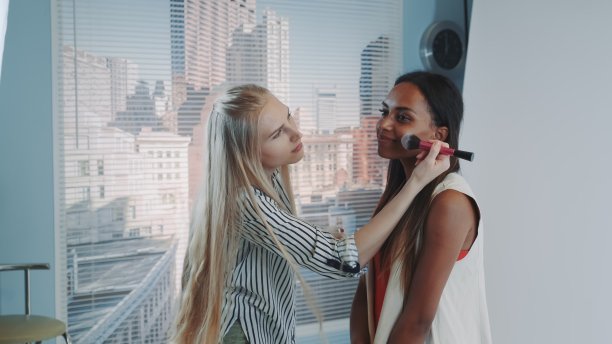 中间的特写化妆师在美丽的混血模特化妆图片下载