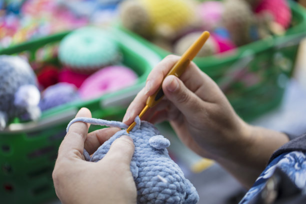 一个针女钩针的手。女人的手指编织玩具。手工工艺。图片下载
