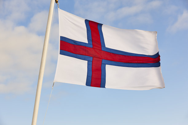 蓝天下飘扬的法罗群岛旗帜。法罗群岛的文化图片下载