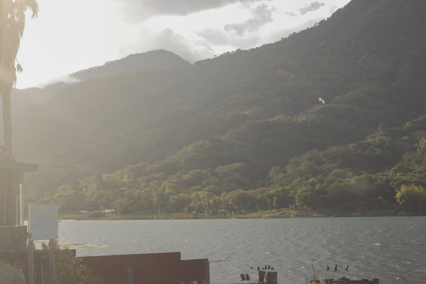 危地马拉阿提特兰湖的日落-天空中的鹈鹕-湖泊和山脉的景观图片下载