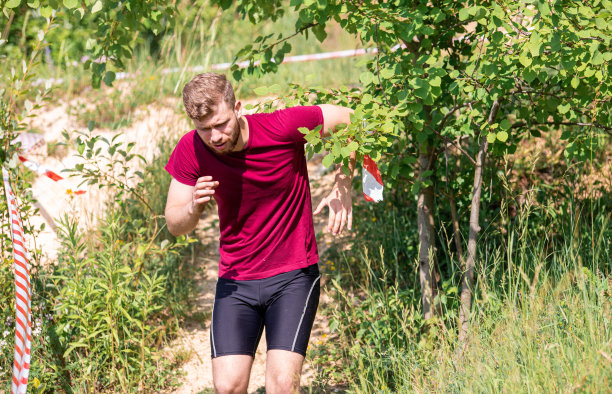 在阳光明媚的日子里，疲惫的跑步者在越野赛跑中奔跑图片下载