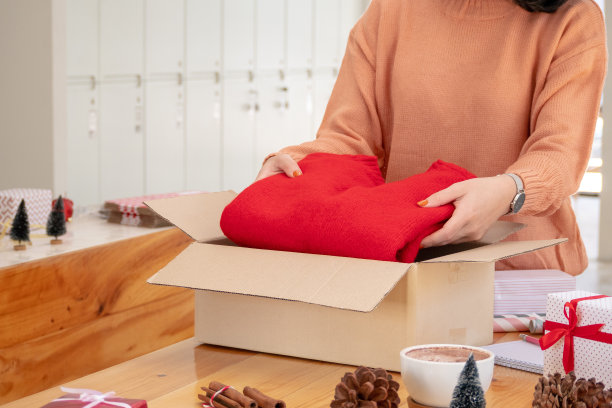 年轻的亚洲妇女包装红色毛衣包装圣诞节或生日礼物礼盒图片下载