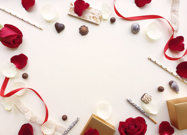 情人节的背景。玫瑰，玫瑰花瓣，巧克力，管和缎带美丽。孤立在淡粉色背景上。情人节的概念。从以上观点。粉红色的地板上有一个中间区域。图片下载