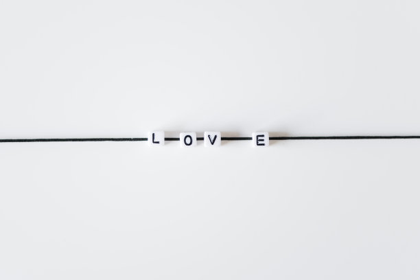 爱的字由字母印在黑色的绳子上。白色背景图片下载
