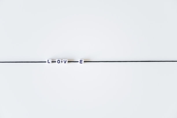 爱的字由字母印在黑色的绳子上。白色背景图片下载