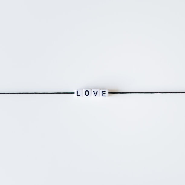 爱的字由字母印在黑色的绳子上。白色背景图片下载