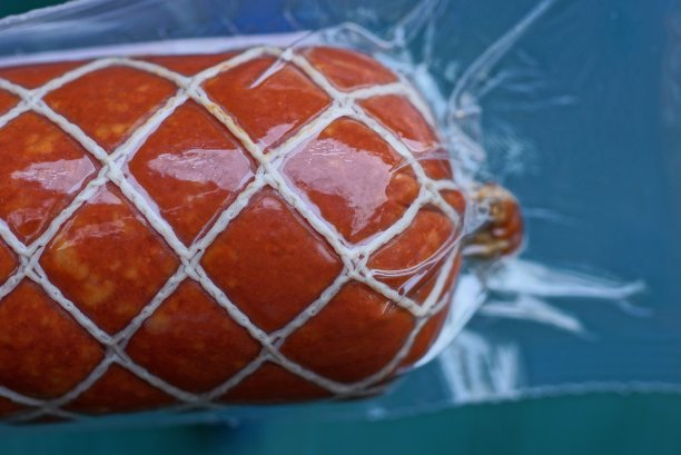 一块红色的意大利腊肠，用白色的线包裹着图片下载