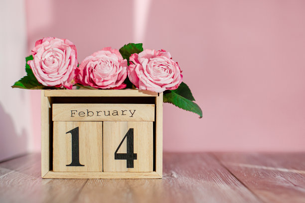 贺卡情人节快乐木制日历和粉红色玫瑰木制背景。副本的空间。图片下载