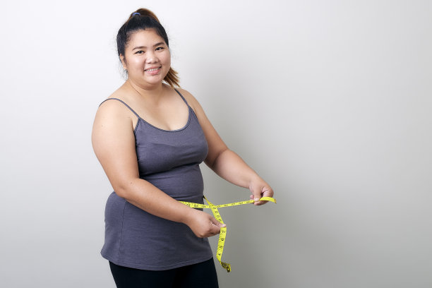 微笑的女人的肖像拿着卷尺白色的背景图片下载