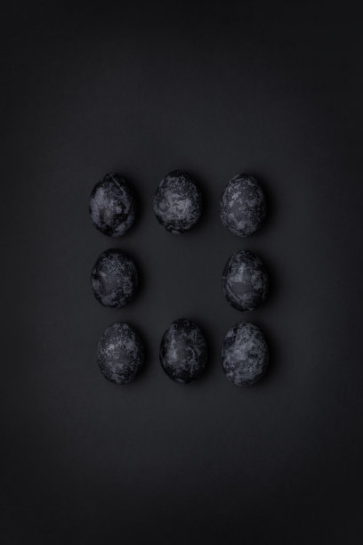 手工制作的单色黑色纹理画鸡蛋方形图案在中间的构图上的黑色背景图片下载