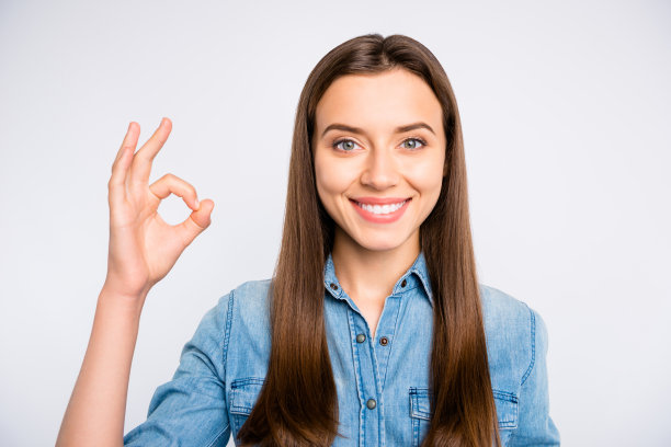 近距离的照片自信的酷推广女孩显示ok标志挑选技巧穿休闲风格的衣服孤立的白色背景图片下载