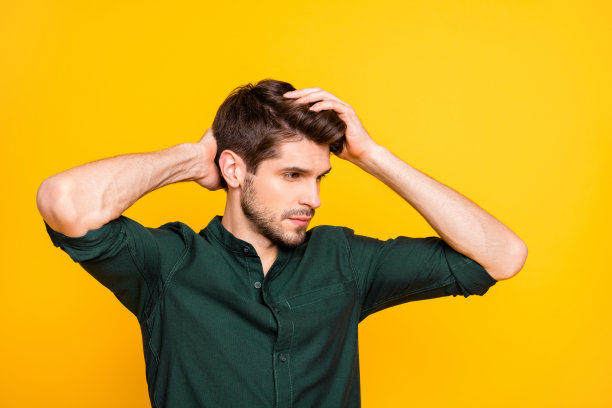 我的头发怎么样?头像侧面照片沉思的家伙看镜子摸他的头发感到体贴新的防皮屑效果洗发水穿休闲装孤立的黄色背景图片下载
