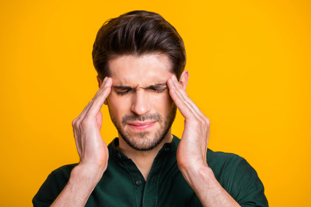 近距离的照片，痛苦的人与鬃毛闭上他的眼睛在一种伤害的疾病在黄色充满活力的背景孤立图片下载