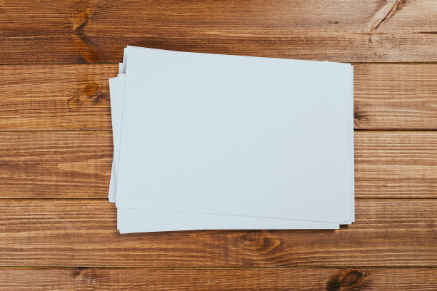俯视图的现代办公桌办公场所与a4纸。品牌空白模板。照片空白表格。为作品集设计模拟。图片下载