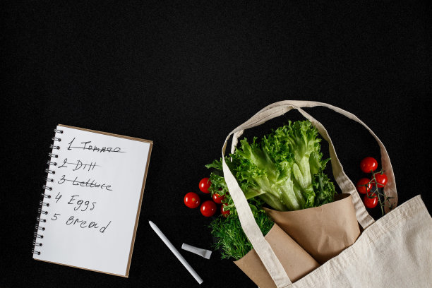 黑色背景上有新鲜蔬菜和购物单。圣女果，莳萝，生菜，帆布袋。环保、负责任的消费图片下载