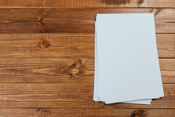 俯视图的现代办公桌办公场所与a4纸。品牌空白模板。照片空白表格。为作品集设计模拟。图片下载