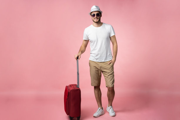 带着彩色背景的手提箱、护照和机票的男士。图片下载