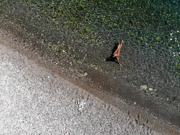 一名女子漂浮在海上的无人机照片。图片下载