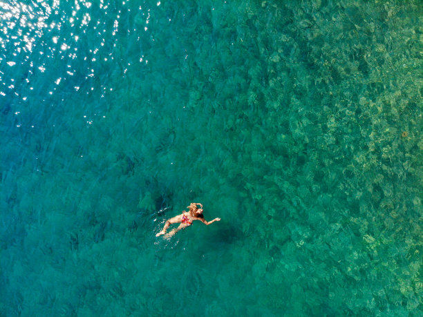一名女子漂浮在海上的无人机照片。图片下载