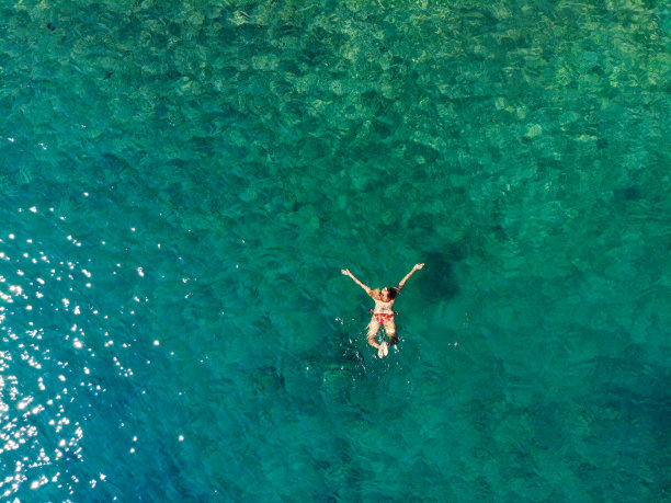 一名女子漂浮在海上的无人机照片。图片下载