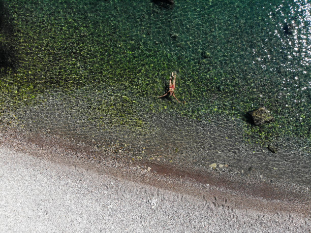 一名女子漂浮在海上的无人机照片。图片下载