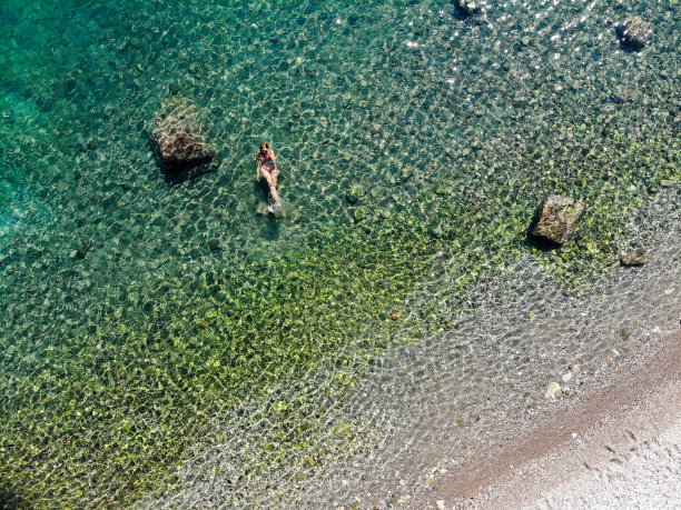 一名女子漂浮在海上的无人机照片。图片下载
