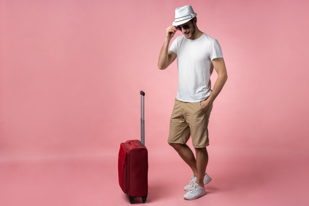 带着彩色背景的手提箱、护照和机票的男士。图片下载