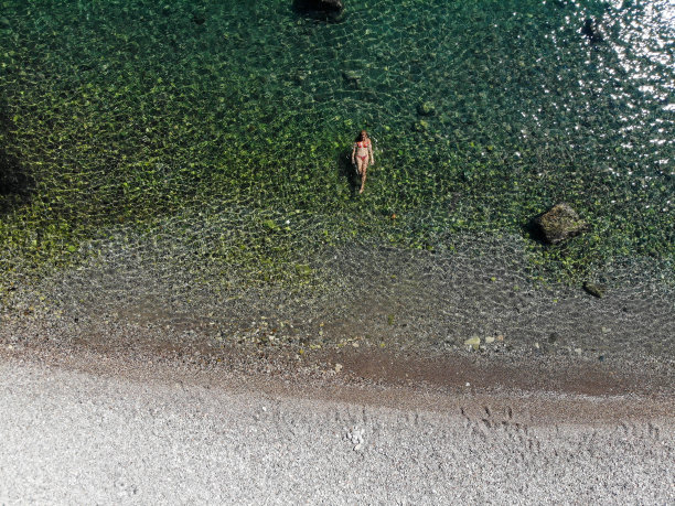 一名女子漂浮在海上的无人机照片。图片下载