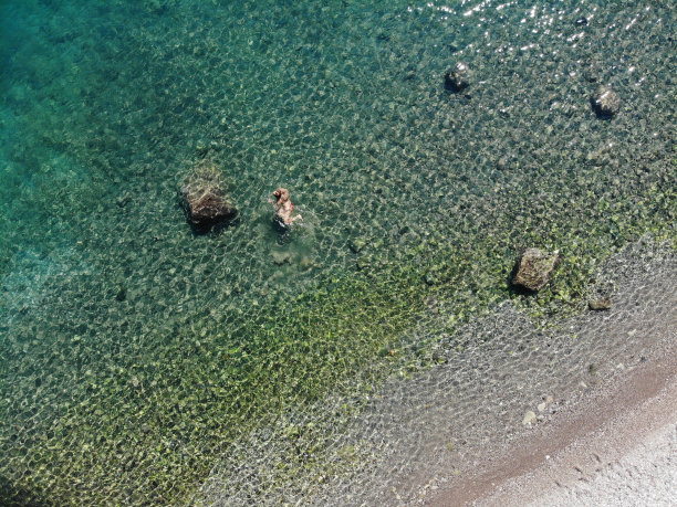 一名女子漂浮在海上的无人机照片。图片下载