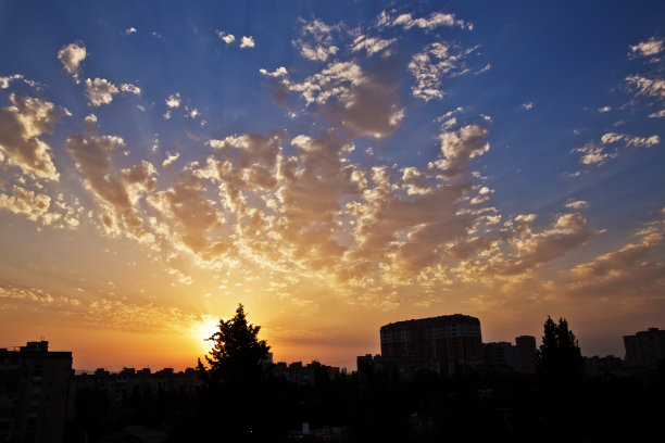 即时照片，色调图像。美丽的暴风雨日落天空。多云的抽象背景。夕阳的颜色。黑色的云。橙色和黄色日落。图片下载