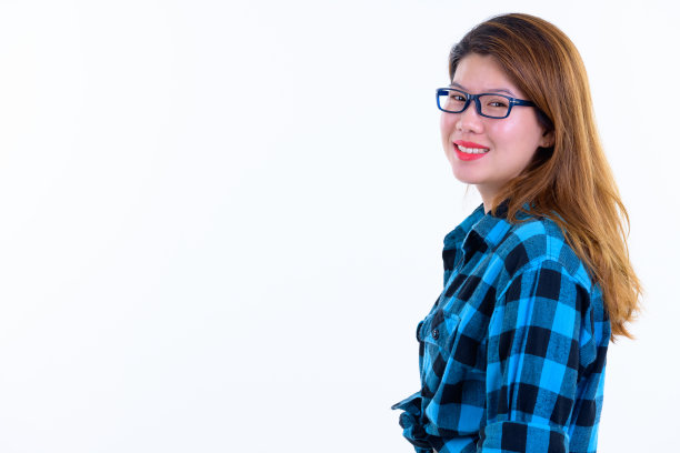 侧面视图的快乐年轻美丽的亚洲潮女人看着相机图片下载