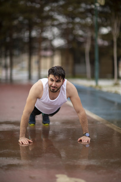 一个年轻的运动员在雨中锻炼的照片图片下载
