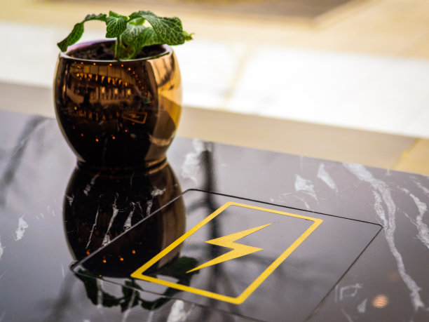 在有复印空间的公共场所免费充电站。在咖啡馆里使用内置的台式充电板为智能手机充电图片下载