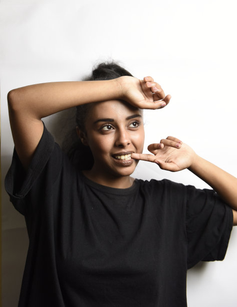 有着一头黑发的中东年轻女子。室内照片的精彩女模特在白色的背景。图片下载