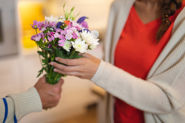 一个年轻人把一束花送给一个年轻的女人图片下载