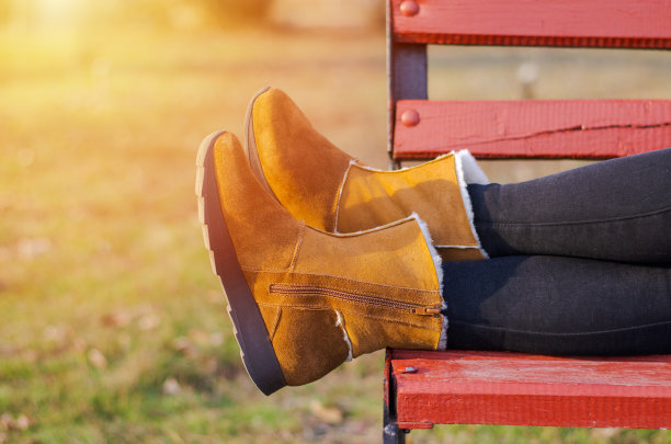 女孩们穿着棕色鞋子的腿躺在木凳上。图片下载