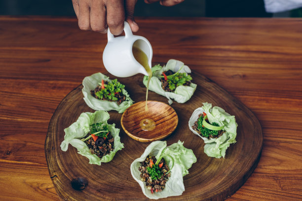 食物图片:卷心菜和肉末，厨师手把酱放在木盘上图片下载