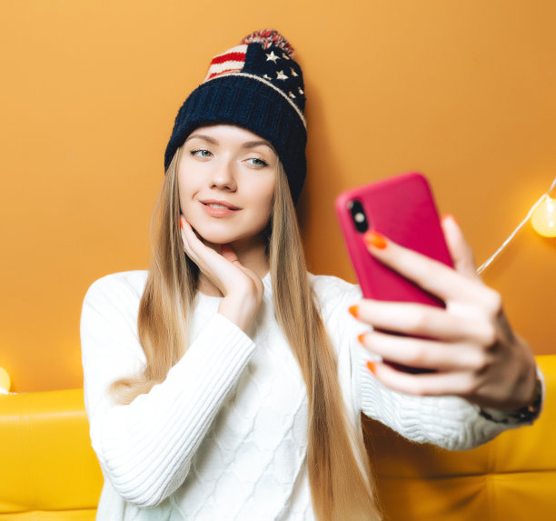 在咖啡馆或办公室里的美丽快乐的女人。她戴着美国帽子。为您的设计复制空间。概念与情感图片下载