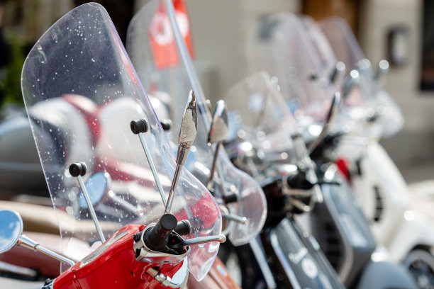 街边有一排经典的摩托车停车场。一个挡风玻璃和反光镜的特写。——图片图片下载