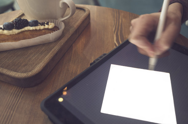 一个小女孩用咖啡和浆果泡芙在写字板上画画图片下载