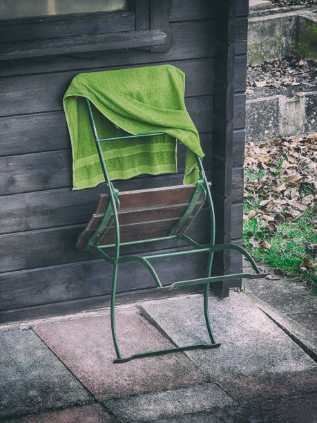 靠在小木屋上的花园椅图片下载