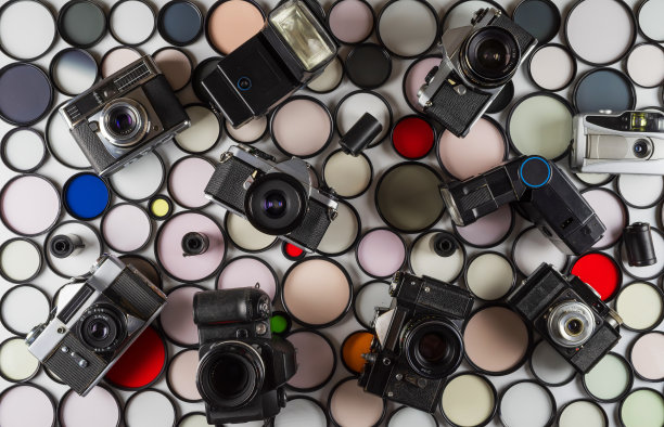 老式胶片相机和闪光灯放在彩色玻璃滤镜的背景上图片下载