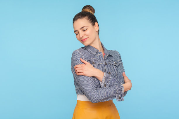 我爱自己：自信迷人的盘发女性拥抱自己，表达愉悦的自爱图片下载