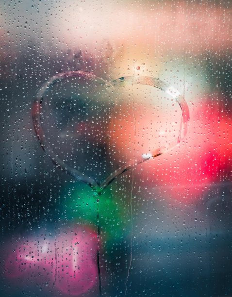 雨天在雾蒙蒙的玻璃上画的心，上面有许多水滴图片下载