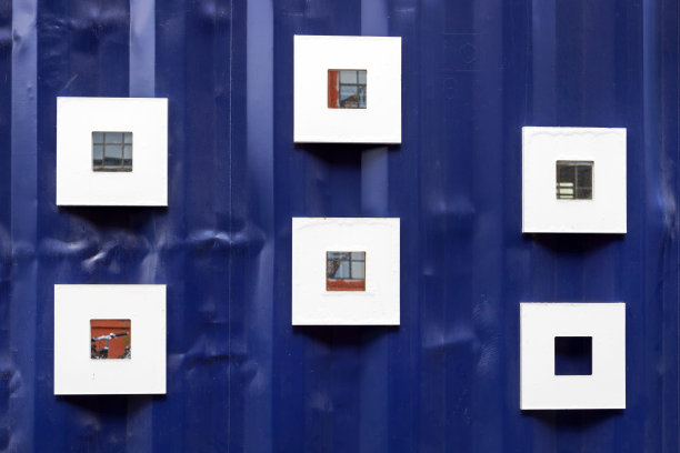 蓝色铁墙上的小镜子。外观设计。体系结构。图片下载