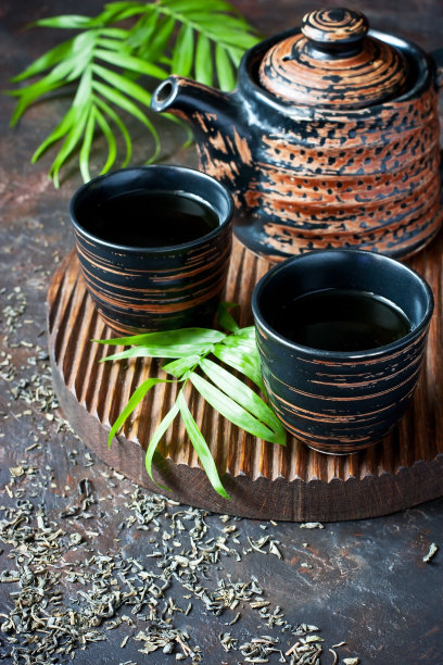 深色背景上的亚洲风陶瓷碗和茶壶图片下载