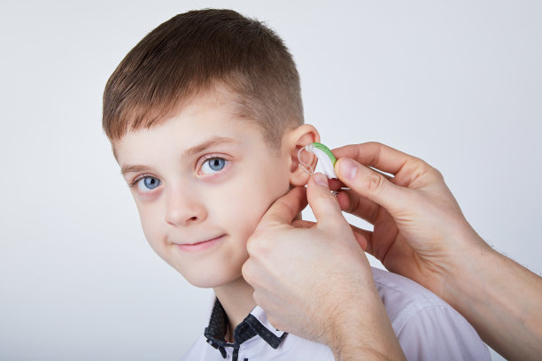 戴着助听器的小男孩。素材图片