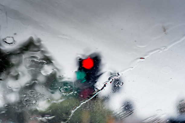 暴雨袭击了这个城市。透过挡风玻璃几乎看不到交通灯。图片下载