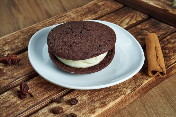 海绵可可饼干，里面有白奶油，放在白色的盘子里。美味的咖啡甜点。食物照片平放。面包店。无比派图片下载